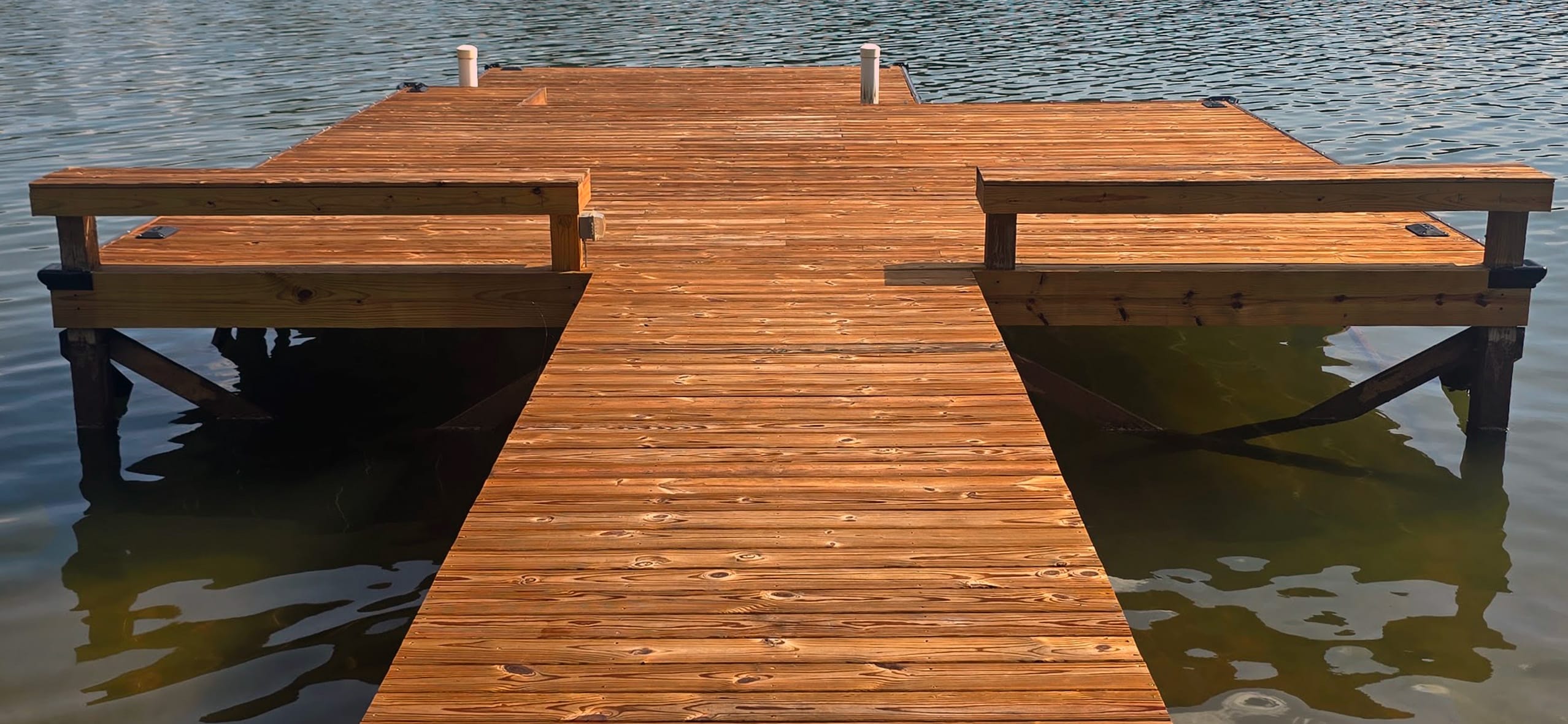 Same Lake Martin dock in Equality, Alabama, after repair and re-decking with new sealed pressure-treated pine boards. bumper edging and bench rails